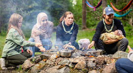 Speidere som griller pinnebrød over bål.