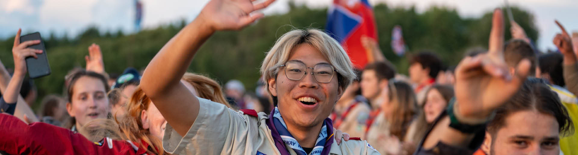 Speider som smiler til kamera under tak mens han danser jenka.