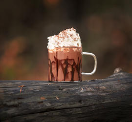 Fotografi av en kopp med kakao og krem.
