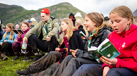 Speidere som synger allsang rundt leirbålet.