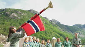 Speidere som ruller ut flagget.