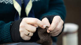 Nærbilde av strikketøyet til en speiderleder.
